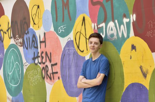 Teen boy portrait near graffiti wall