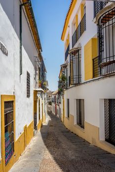 Empty streets of Cordoba on a bright summer day with blue sky and buildings on either side