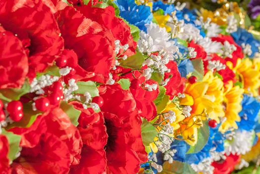 a lot of homemade artificial colored flowers in a beautiful sunny day