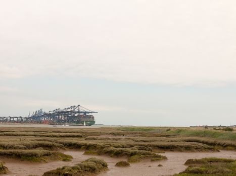 blue sea structure cranes at cargo dock loading in distance felixstowe essex