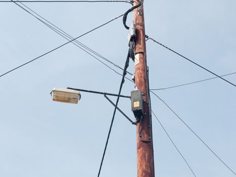 a lamp post with various wires and boxes