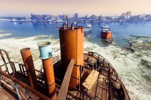 A large tanker ship is being renovated in shipyard