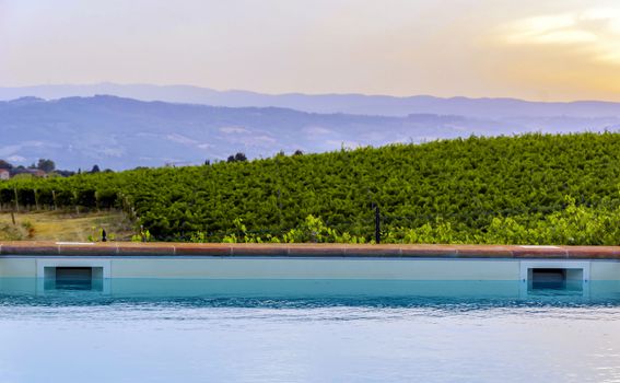 Poolside iat sunset in an italian countryside