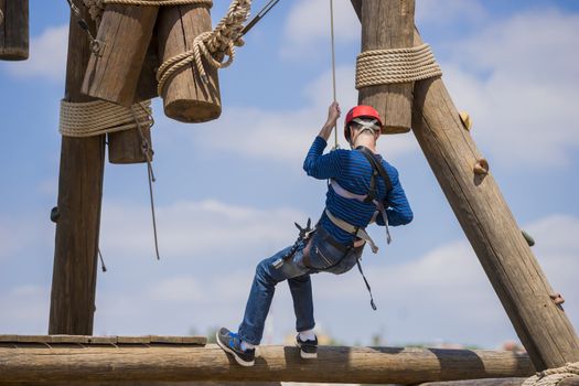Extreme professional videographer during shooting on climbing tower working under extreme conditions. He has a DSLR camera and an action camera.