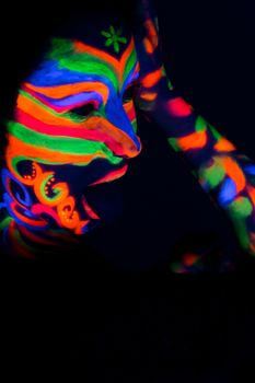 Woman with make up art of glowing UV fluorescent powder.