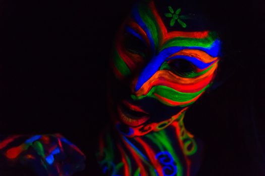 Woman with make up art of glowing UV fluorescent powder.