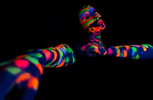 Woman with make up art of glowing UV fluorescent powder.