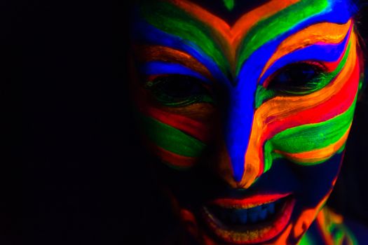 Woman with make up art of glowing UV fluorescent powder.