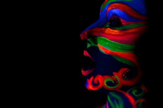 Woman with make up art of glowing UV fluorescent powder.