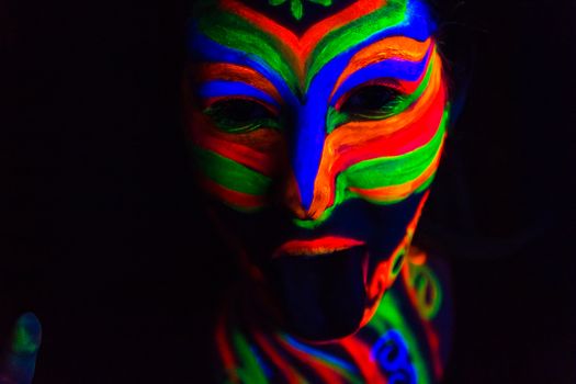 Woman with make up art of glowing UV fluorescent powder.