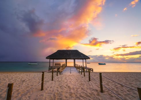 Beautiful sunset in Mauritius Island (flic en flac beach) with Jetty silhouette.