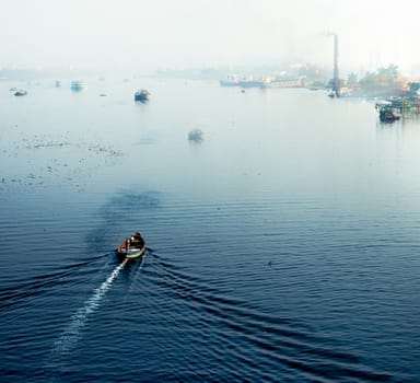 Top view of a white boat sailing in the blue sea