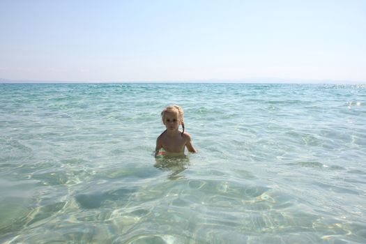 Baby girl enjoying in the clear sea water