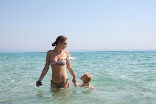Mother and daughter enjoying in the clear sea water