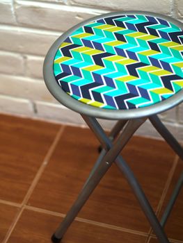 COLOR PHOTO OF STOOL WITH ZIG ZAG PATTERN LEATHER
