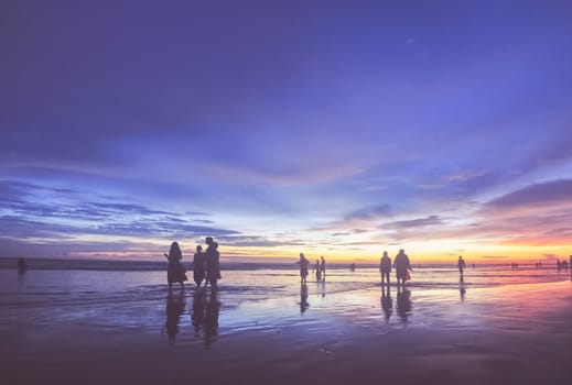 a group of peope are swimming in sea beach