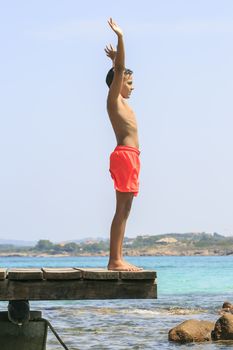 Boy in a Wooden pier on the mediterranean sea