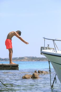 Boy in a Wooden pier on the mediterranean sea