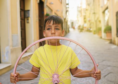 Green eyes boy with bicycle wheel
