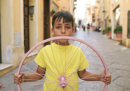 Green eyes boy with bicycle wheel