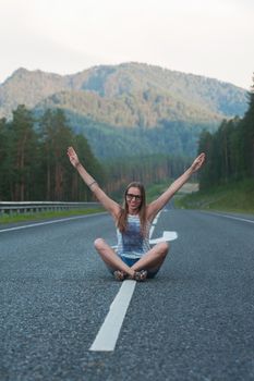 Woman sitting on the beauty road in mountain