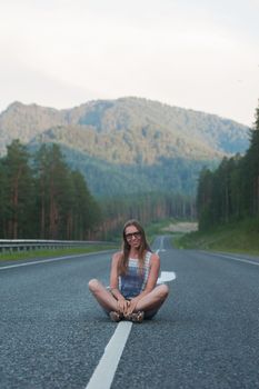 Woman sitting on the beauty road in mountain