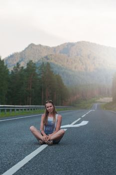 Woman sitting on the beauty road in mountain