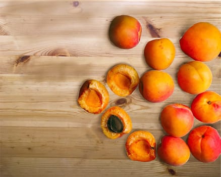 Whole and cut ripe apricots isolated on a wood background 