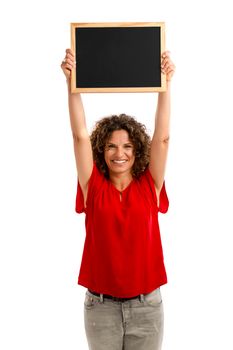 Portrait of a smiling middle aged brunette holding a chalkboard