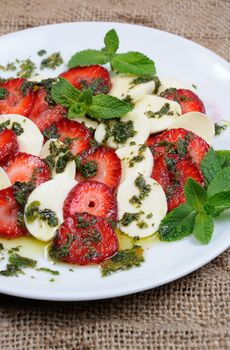 Light snack caprese with strawberries and mozzarella dressed   mint pesto