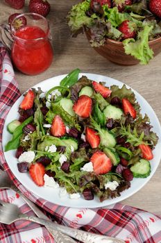 Salad of vinaigrette with strawberries, tender feta and strawberry sauce. Vertical shot.