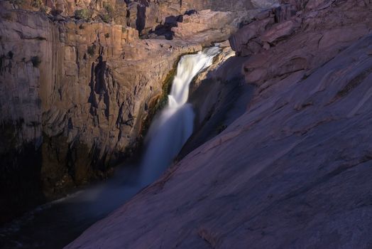 The main Augrabies waterfall after sunset, lighted by a single electric light