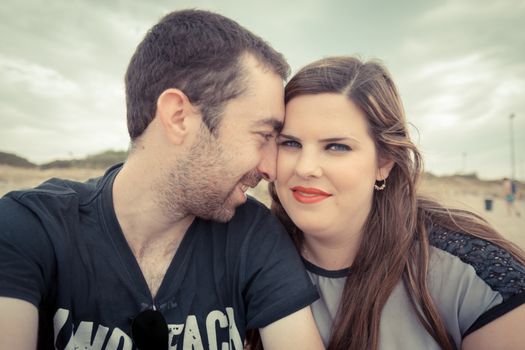 Young couple taking selfie with smartphone or camera at the beach.