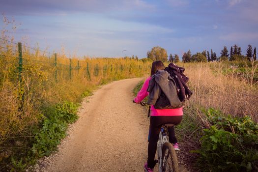 Woman riding a bicycle in the countryside.
