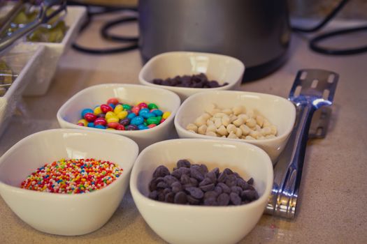 Colorful candy sprinkles and chocolate chips in ceramic bowl
