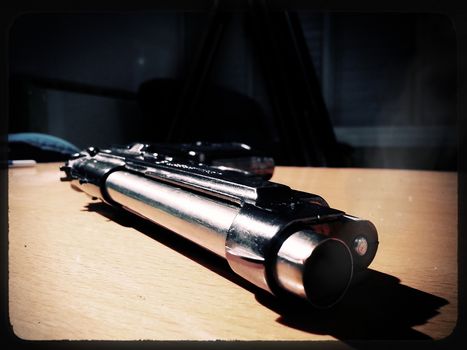Silver 9mm pistol lying on a wooden table.
Smoke coming from the barrel of the gun.