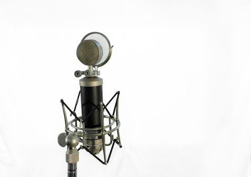 Vocal condenser microphone with wind screen isolated on white background.
