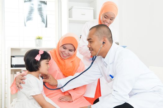 Southeast Asian child patient consulting medical doctor. Muslim family. 