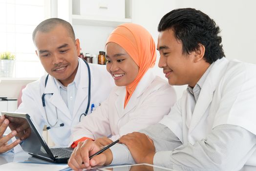 Group of doctors meeting at hospital office. Southeast Asian Muslim medical people.