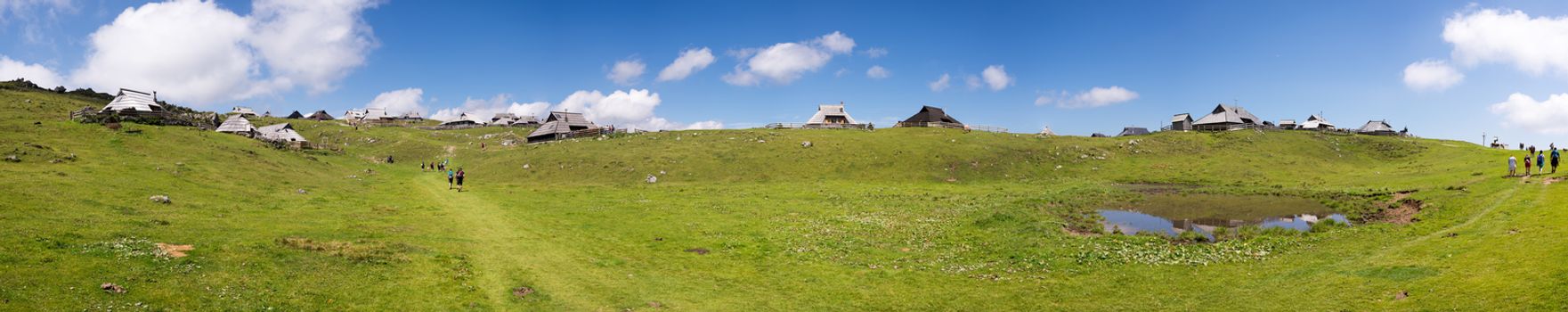 Extreme large panorama of Velika planina plateau, Slovenia, Mountain village in Alps, wooden houses in traditional style, popular hiking destination