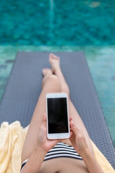 Woman use of mobile phone in swimming pool