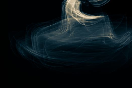 Light painted glowing abstract blue and yellow curved lines on a black background
