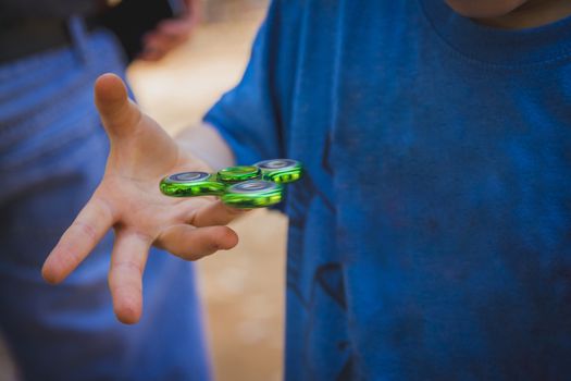 Young boy play with fidget spinner.