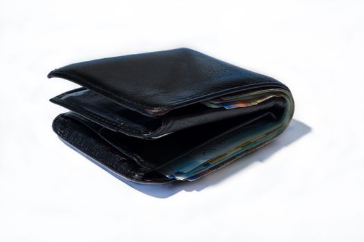 Stack of various of israeli shekel money bills in close black leather wallet.
