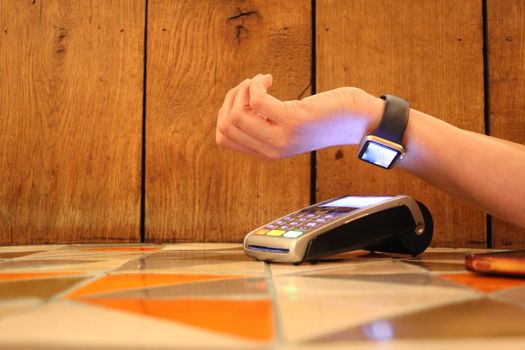 contactless payment watch apple pdq with hand holding credit card ready to pay