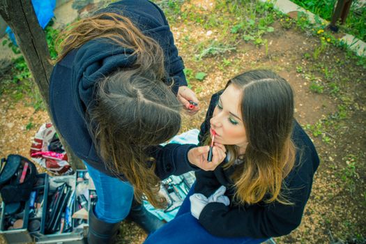 Professional make up artist doing glamour model makeup at work.