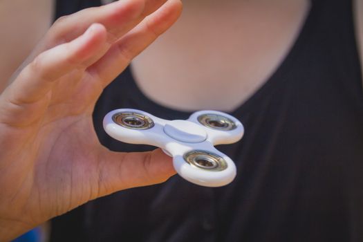 Young girl play with fidget spinner