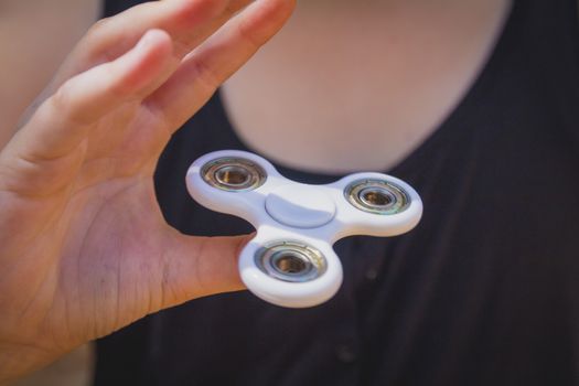 Young girl play with fidget spinner