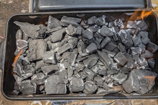 Coals are burned in a BBQ grill. Top view.
