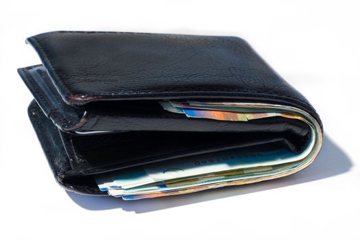 Stack of various of israeli shekel money bills in close black leather wallet.